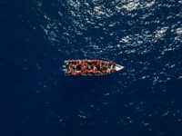 Migrants from Eritrea, Libya and Sudan sail a wooden boat before being assisted by aid wor