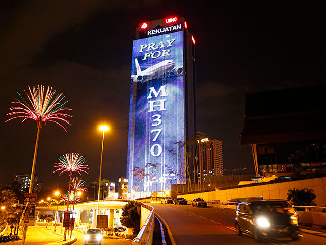 An office building is illuminated with lights displaying "Pray for MH370" in Kuala Lumpur,