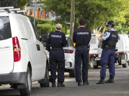 Police stand near houses vandalized with anti-Israel slogans in the Sydney suburb of Wooll