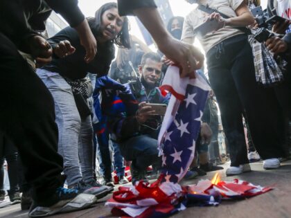 People burn an American flag in Los Angeles, Saturday, Nov. 7, 2020. Democrat Joe Biden de