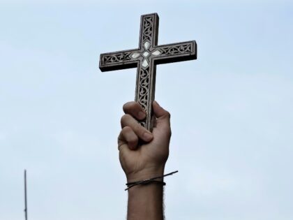 A Syrian Christian man holds u a cross in Damascus, Syria, Tuesday, Dec. 24, 2024, during