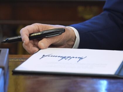 President Donald Trump signs executive orders in the Oval Office of the White House, Tuesd