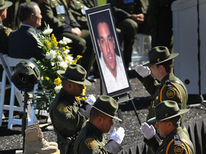 U.S. Border Patrol agents salute while standing vigil over the boots and helmet of slain c