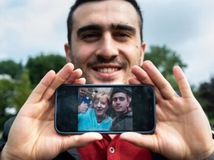 Syrian refugee Anas Modamani poses in a park in Berlin on September 1, 2021, displaying th