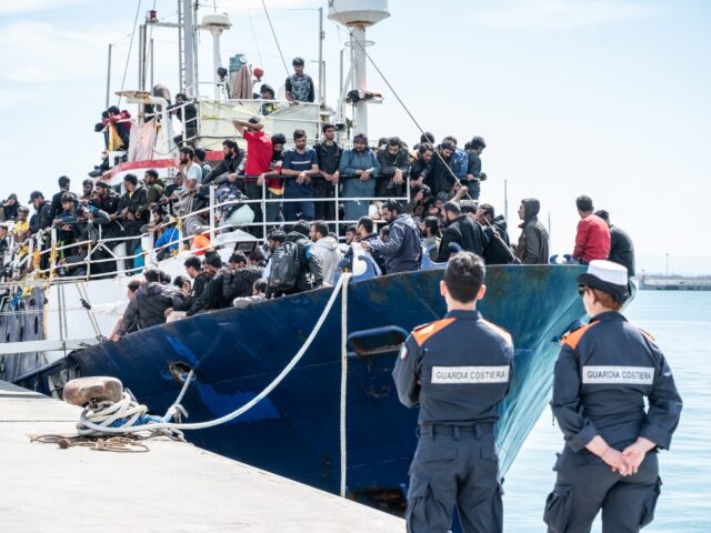 CATANIA, ITALY - APRIL 12: Two Coast Guard soldiers watch the docking of the fishing boat