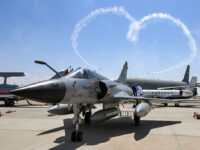 Helicopters release smoke trails as they perform stunts behind a French-built Egyptian Air