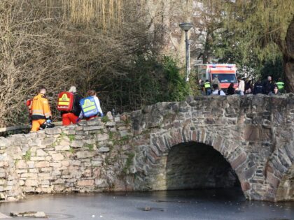 22 January 2025, Bavaria, Aschaffenburg: Rescue workers and forensic experts walk up a sma