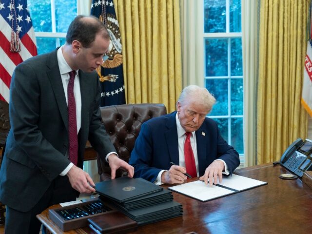 US President Donald Trump signs an executive order during a ceremony in the Oval Office of