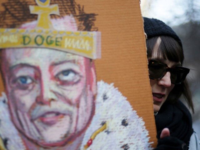 A person holds a sign with an image of Elon Musk during a protest against US President Don