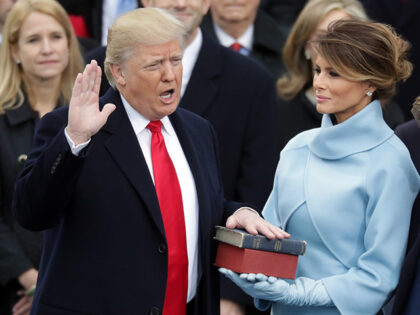 (L-R) U.S. President Donald Trump takes the oath of office as his wife Melania Trump holds