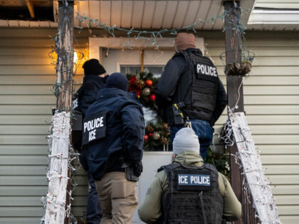 US Immigration and Customs Enforcement (ICE) agents knock on the door of a residence durin