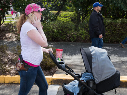 A woman pushes her stroller while open carrying her pistol on the Washington State Capitol