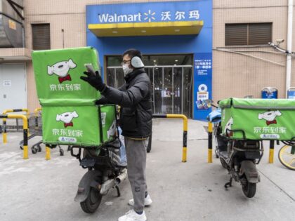 A delivery worker for JD Daojia, operated by Dada Nexus Ltd., outside a Walmart Inc. store