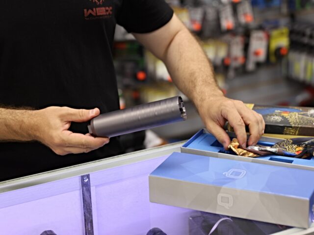 DELRAY BEACH, FLORIDA - MARCH 24: Ian Brabender helps a customer buying a gun suppressor a