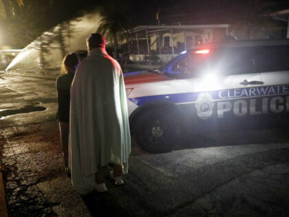 Residents at the Bayside Waters watch EMS personnel respond after a small plane crashed in