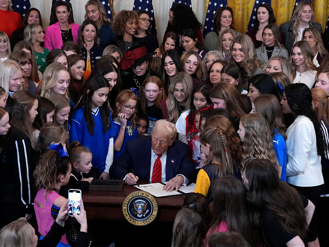 WASHINGTON, DC - FEBRUARY 05: U.S. President Donald Trump joined by women athletes signs t