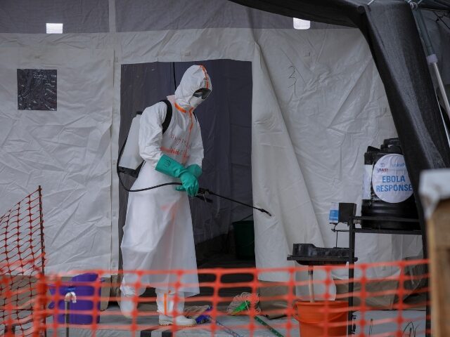 FILE - A medical worker disinfects a tent used for suspected Ebola victims inside the Ebol