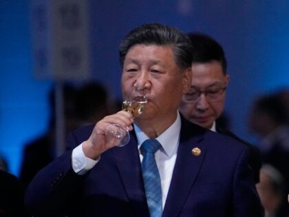 Russian President Vladimir Putin and Chinese President Xi Jinping hold glasses during a fe