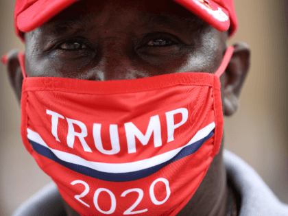 A supporter of U.S. President Donald Trump wears a campaign hat and mask ahead of a rally